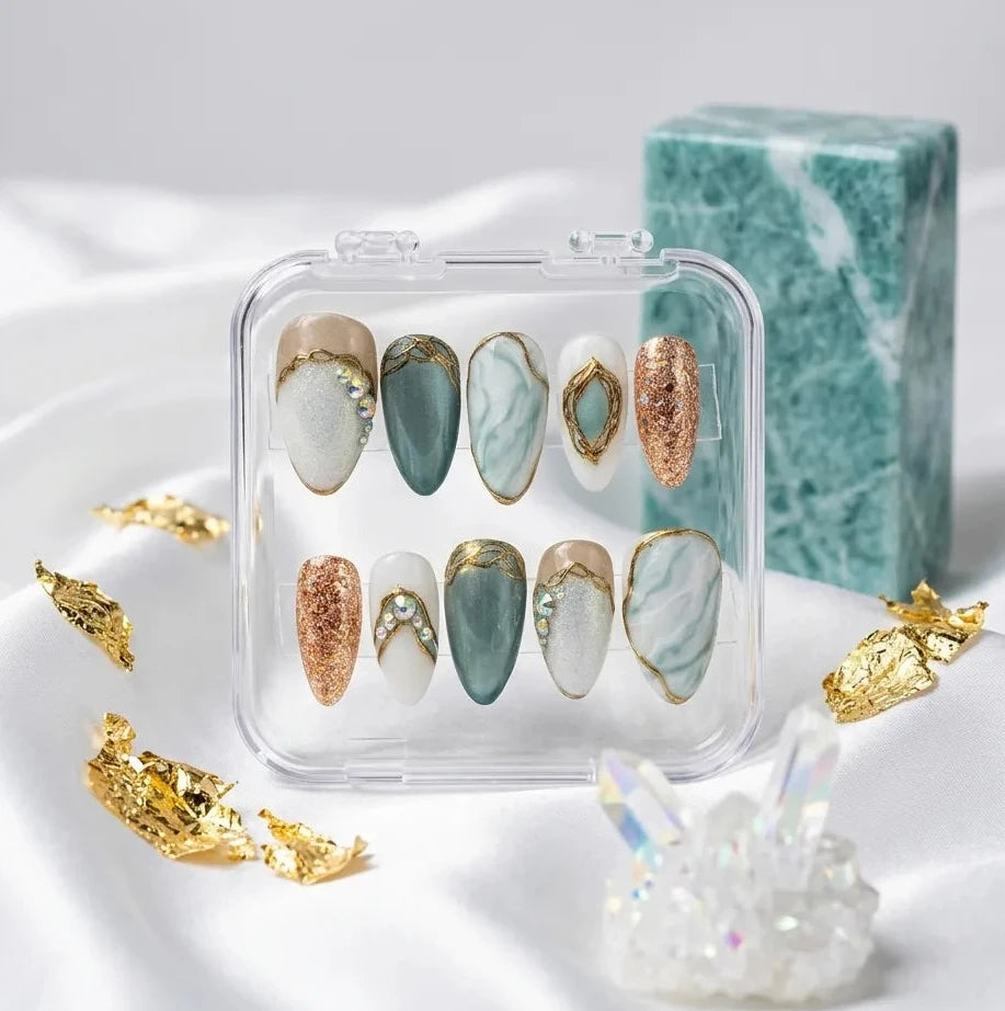 Set of nail art designs in a clear case on a white fabric background.Handmade reusable press on nails