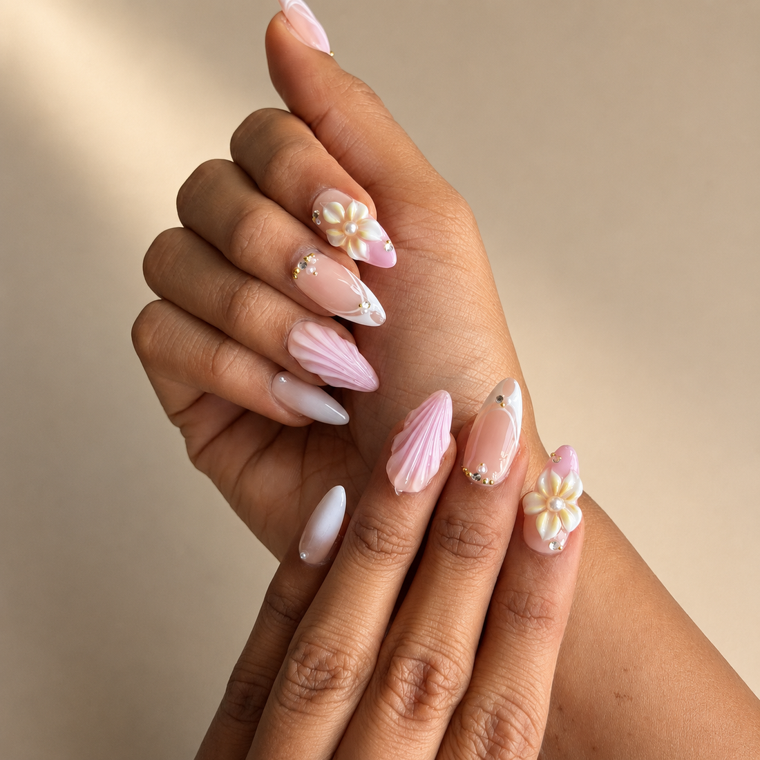Set of pink and gold nail art designs in a clear plastic case with decorative pearls on a light background.